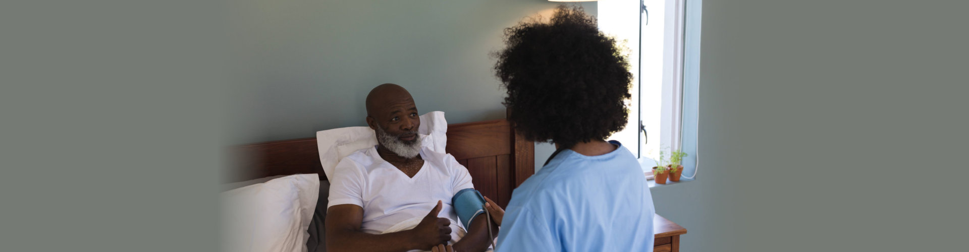 nurse checking blood pressure of senior man